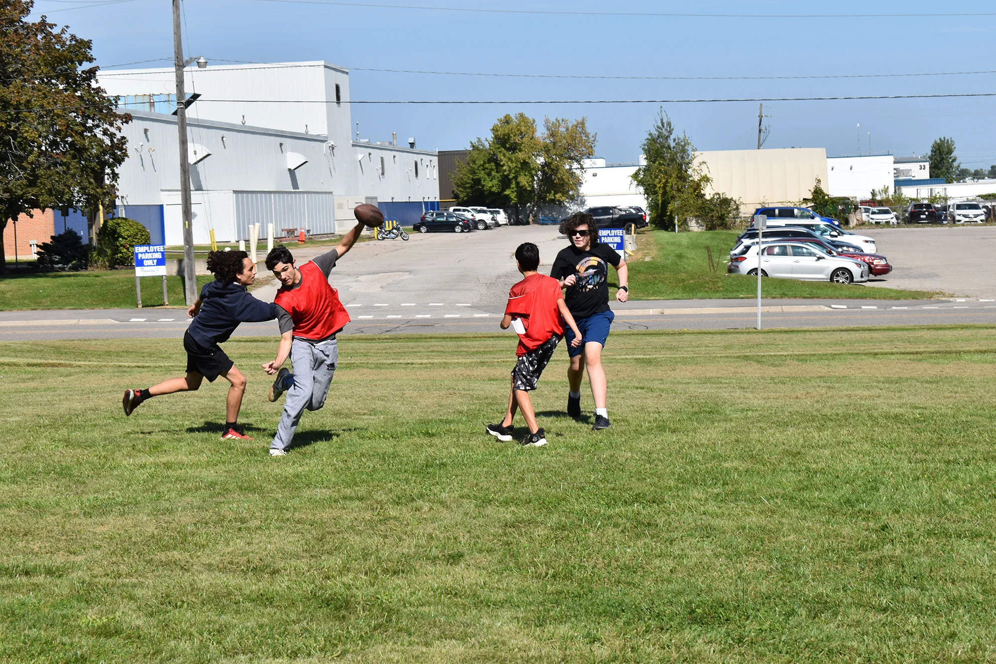 group of students plays flag football on grasyy field
