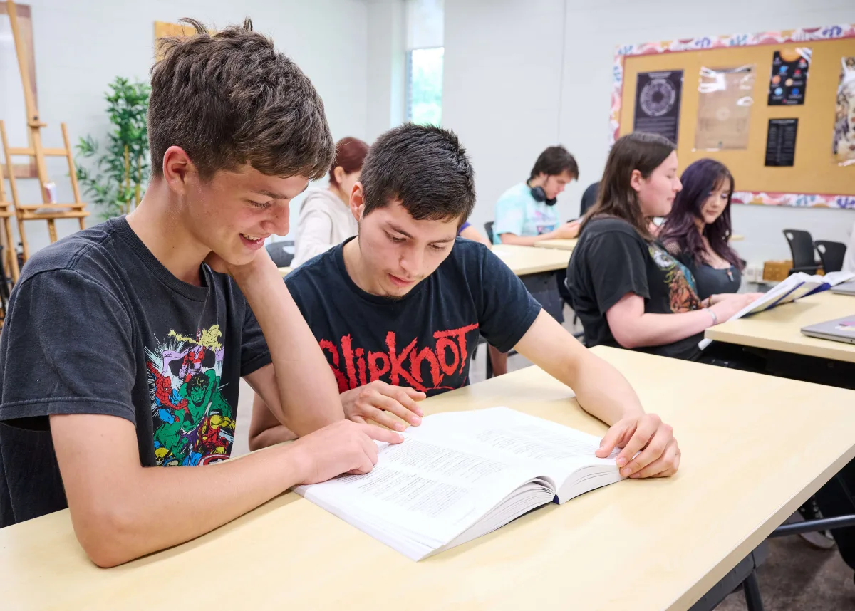 Students are reading a class material in pairs