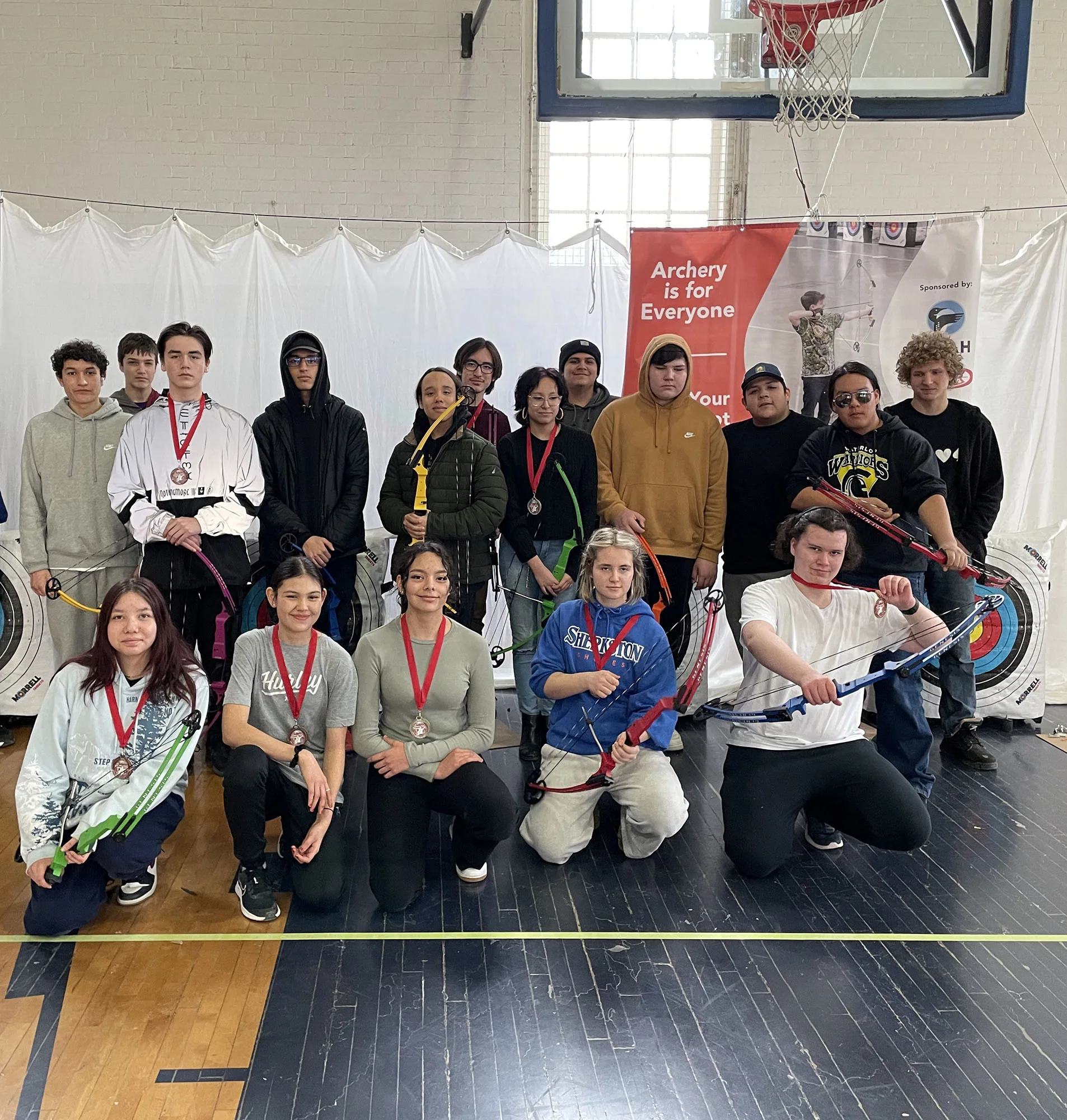 group of archery students posing for photo with their medals