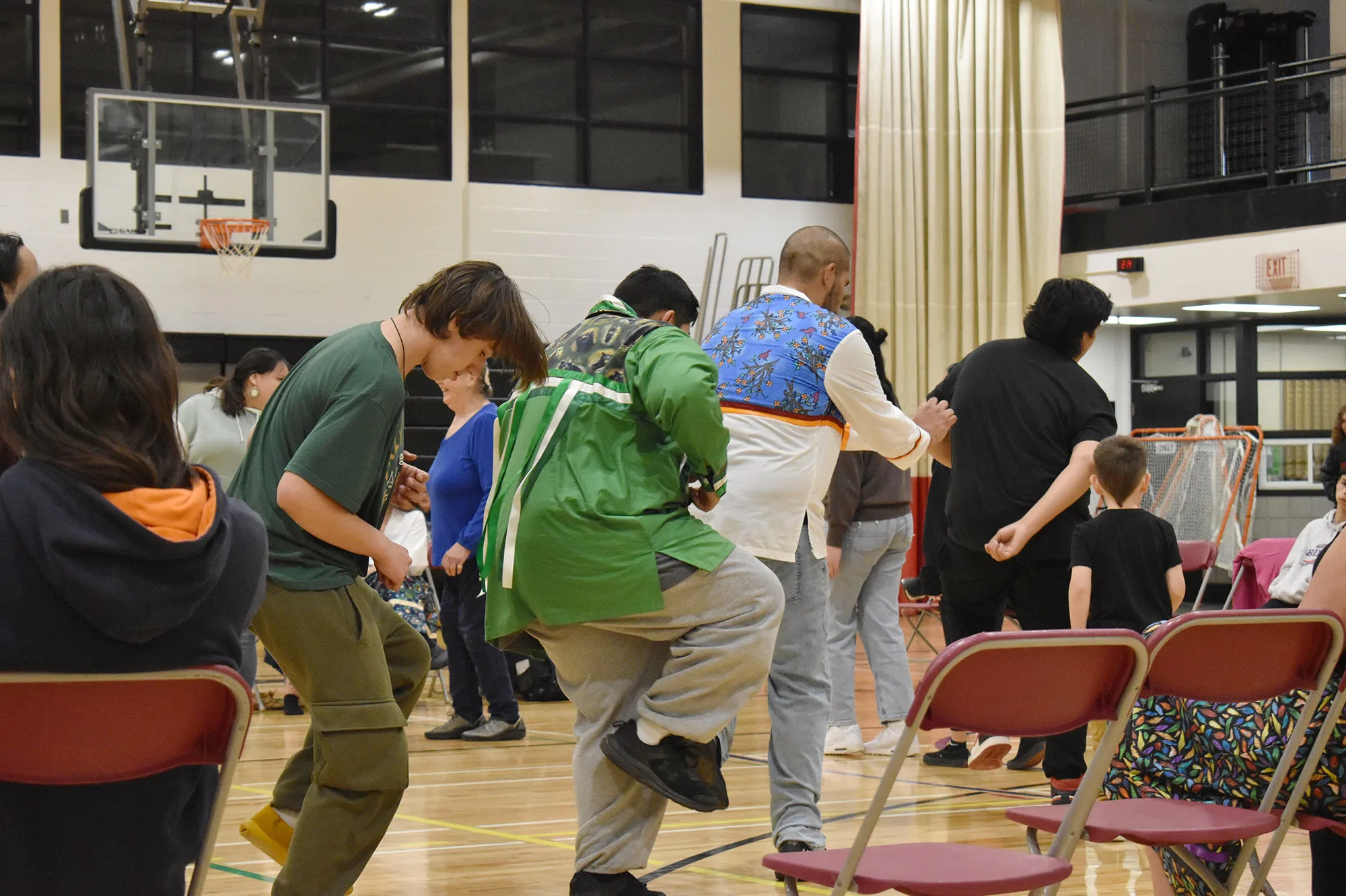 group of young people participating in a cultural dance inside of a gymnasium