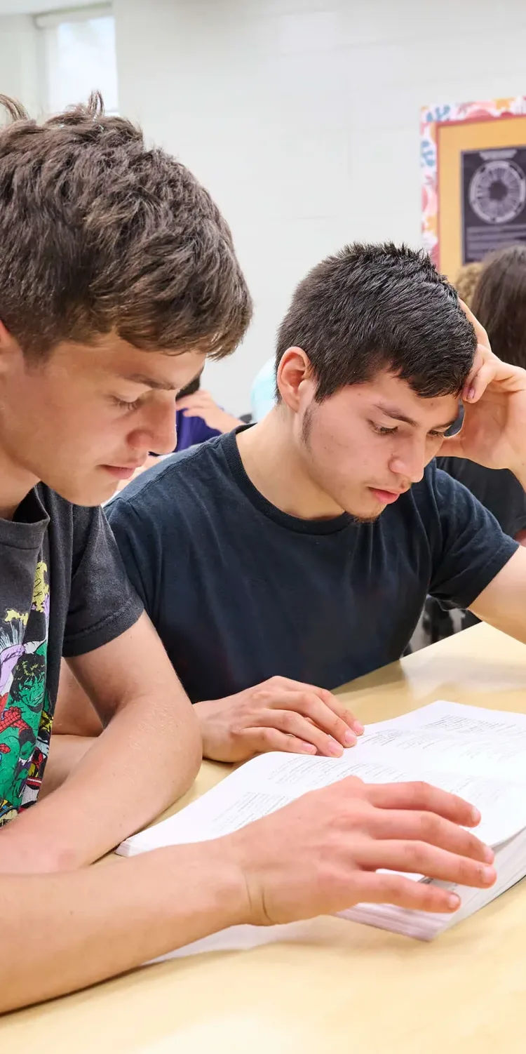 Students reading a book, having a business class