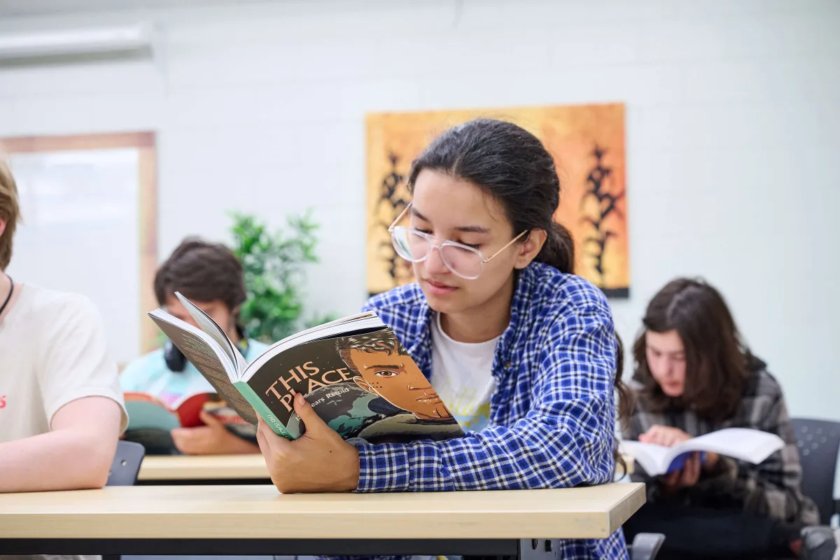 Young men is reading a book in a classroom