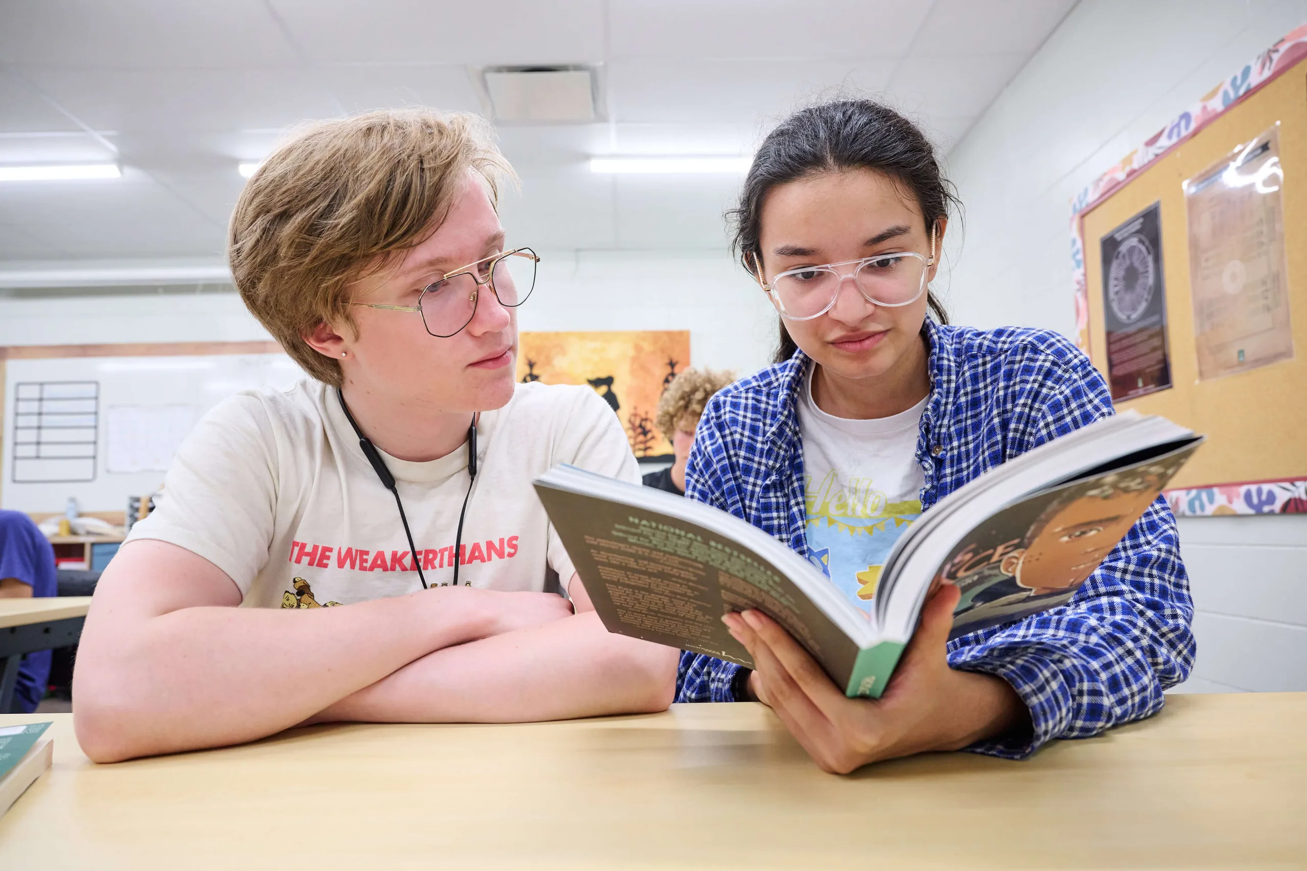 Young men looking down at the book.