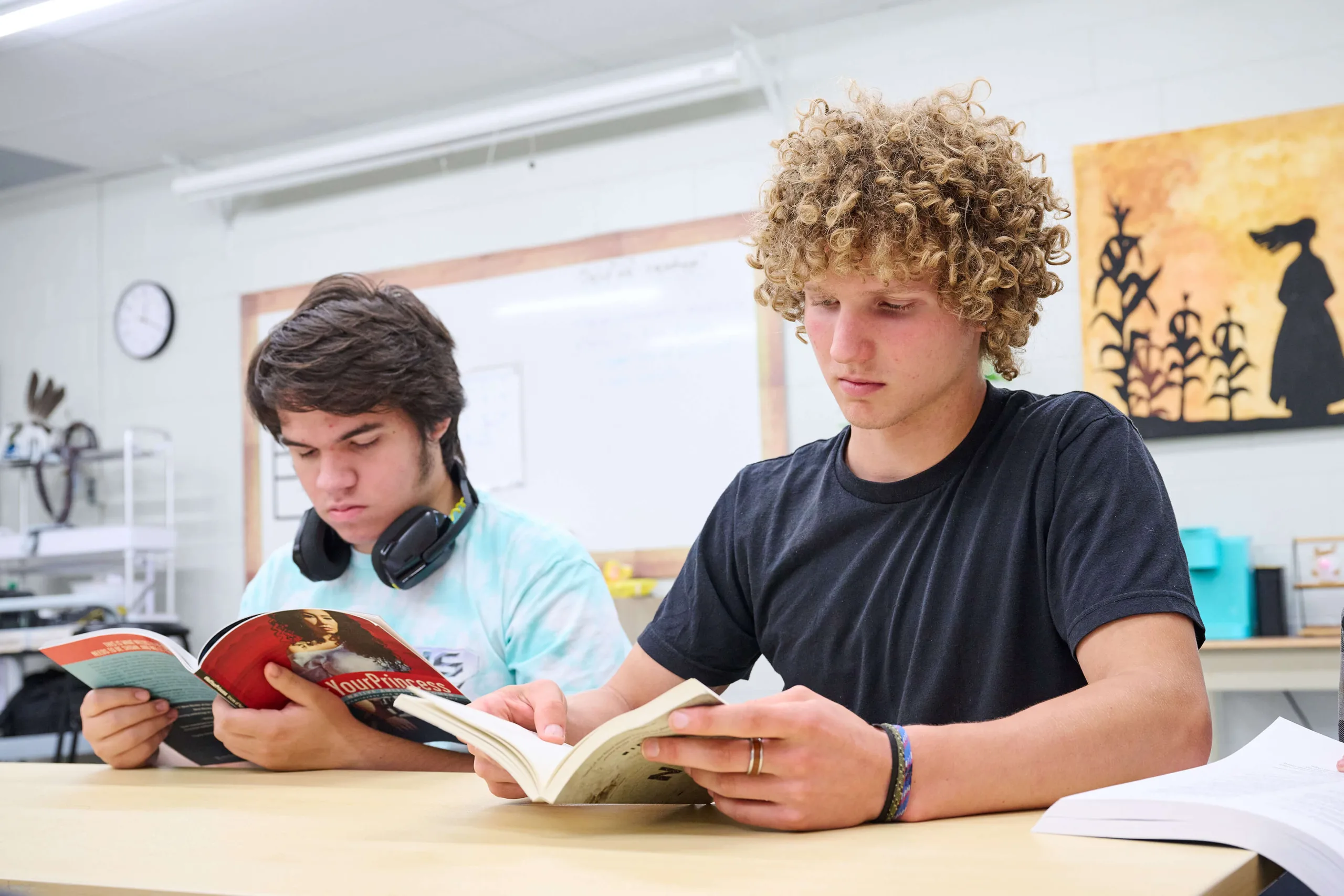 Young men reading a book and having an English class.