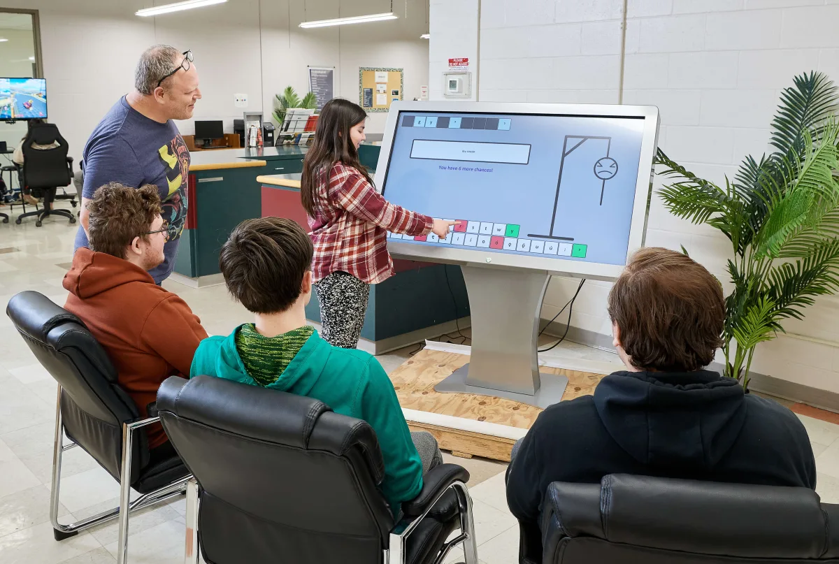 Students exploring a digital screen possibilities during a technology class