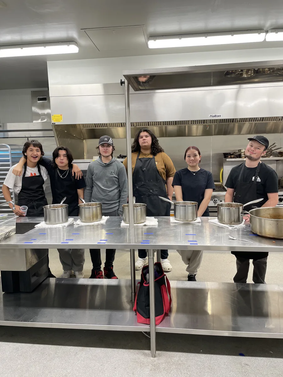 students wearing aprons in an industrial kitchen